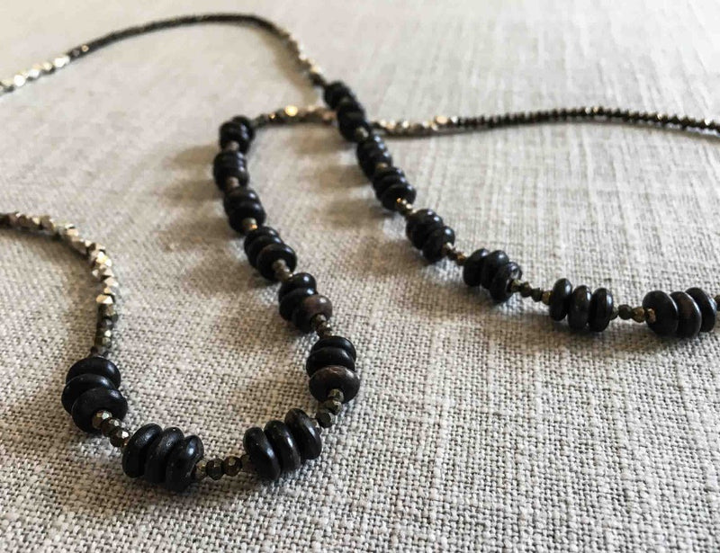 closeup of gemstone bead necklace comprising black horn, silver and pyrite