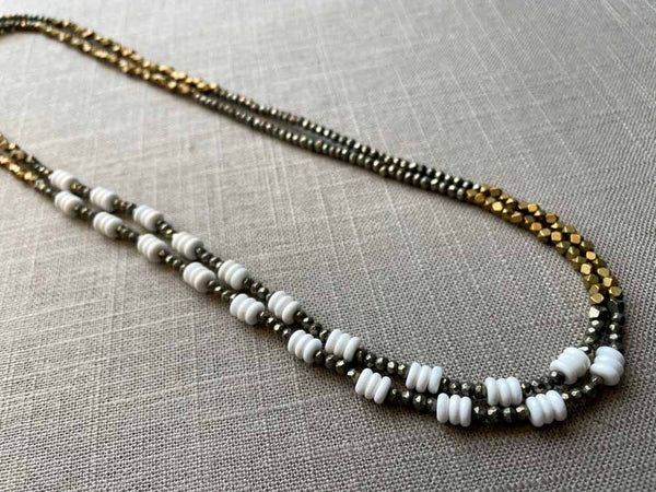 top view of gemstone bead necklace comprising white shell, bronze, dark grey pyrite