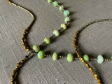 closeup of gemstone bead necklace comprising green chrysoprase, bronze and dark grey pyrite