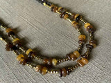 side view of gemstone bead necklace comprising brown horn, dark bronze and golden pyrite