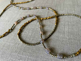 closeup of gemstone bead necklace comprising grey moonstone, bronze and dark grey pyrite