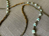 closeup of gemstone bead necklace comprising blue amazonite, bronze and dark grey pyrite