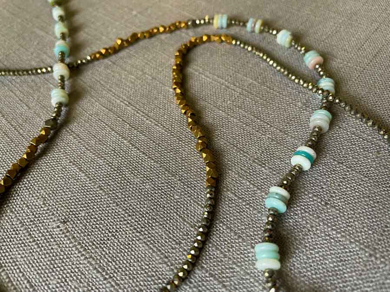 closeup of gemstone bead necklace comprising blue amazonite, bronze and dark grey pyrite