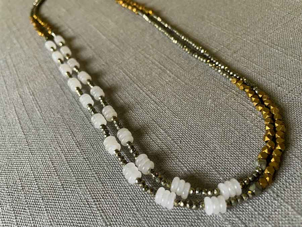 top view of gemstone bead necklace comprising white moonstone, bronze and dark grey pyrite