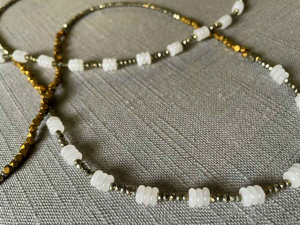 closeup of gemstone bead necklace comprising white moonstone, bronze and dark grey pyrite