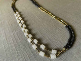 top view of gemstone bead necklace comprising white moonstone, dark bronze and golden pyrite