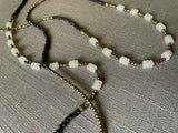 closeup of gemstone bead necklace comprising white moonstone, dark bronze and golden pyrite