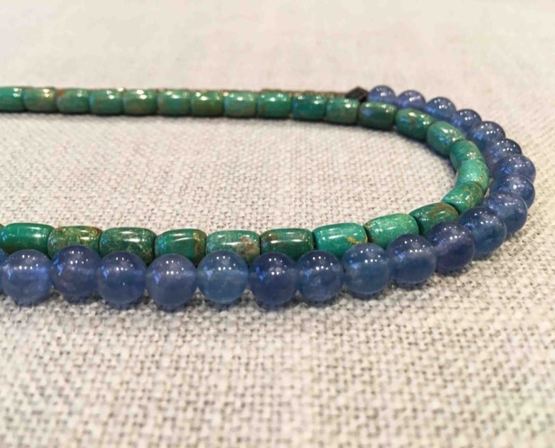 side view of gemstone bead necklace comprising blue kyanite, teal iolite and dark grey pyrite