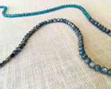 closeup of gemstone bead necklace comprising blue kyanite, teal iolite and pyrite