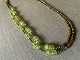 top view of gemstone bead necklace comprising green prehnite, bronze and dark grey pyrite