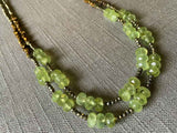 side view of gemstone bead necklace comprising green prehnite, bronze and dark grey pyrite