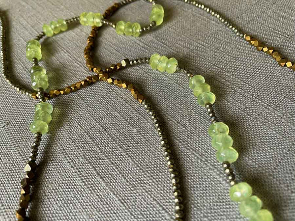 closeup of gemstone bead necklace comprising green prehnite, bronze and dark grey pyrite