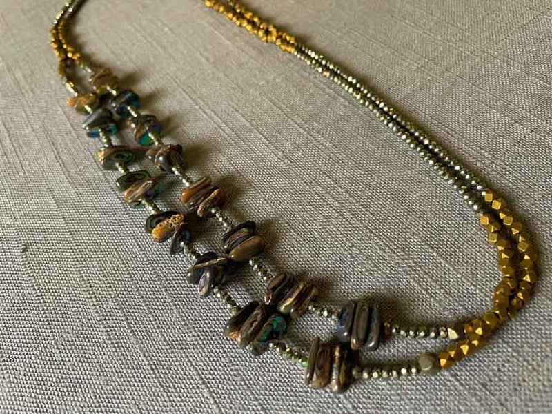 top view of gemstone bead necklace comprising black Tahitian shell, bronze and dark grey pyrite