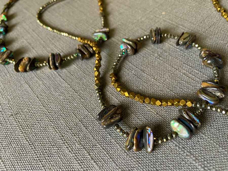 closeup of gemstone bead necklace comprising black Tahitian shell, bronze and dark grey pyrite