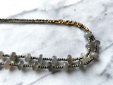 side view of gemstone bead necklace comprising grey moonstone, dark grey pyrite and bronze