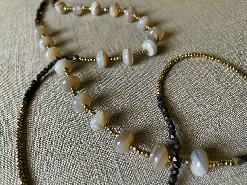 closeup of gemstone bead necklace comprising grey moonstone, dark bronze and golden pyrite