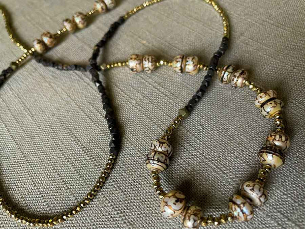 closeup of gemstone bead necklace comprising neutral prayer beads, dark bronze and golden pyrite