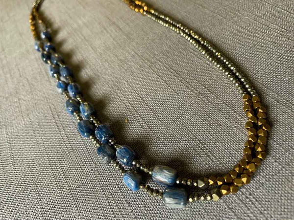 top view of gemstone bead necklace comprising blue kyanite, bronze and dark grey pyrite