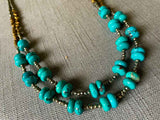 side view of gemstone bead necklace comprising turquoise, bronze and dark grey pyrite