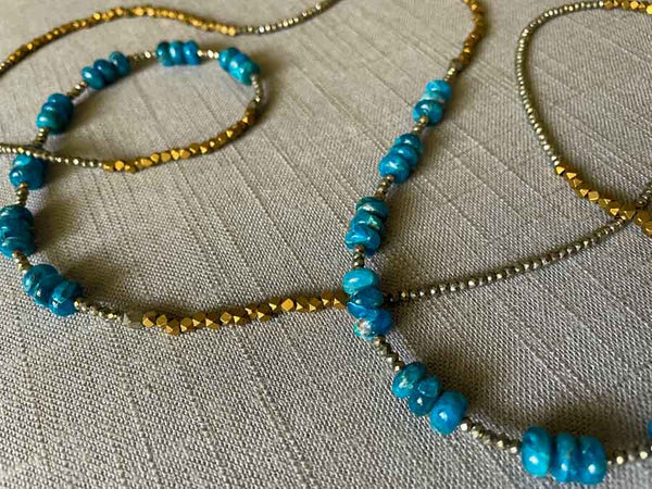 closeup of gemstone bead necklace comprising blue apatite, bronze and dark grey pyrite