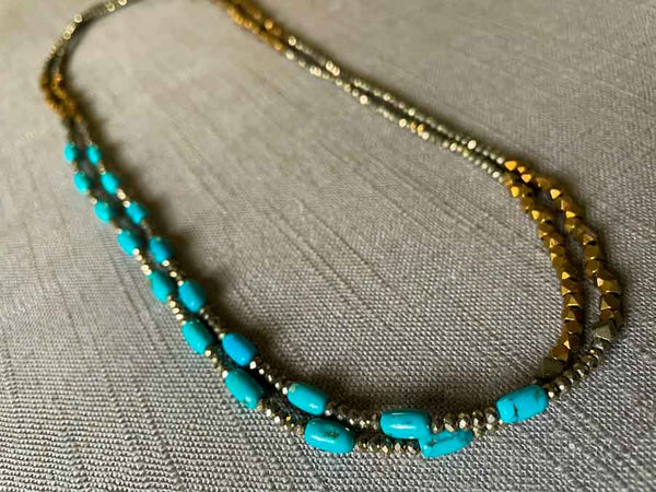 top view of gemstone bead necklace comprising turquoise, bronze and dark grey pyrite