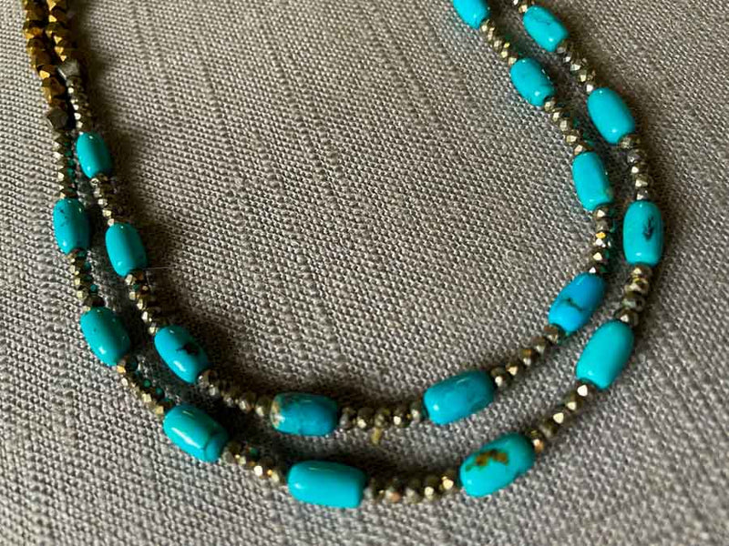 side view of gemstone bead necklace comprising turquoise, bronze and dark grey pyrite