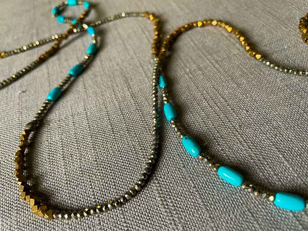 closeup of gemstone bead necklace comprising turquoise, bronze and dark grey pyrite