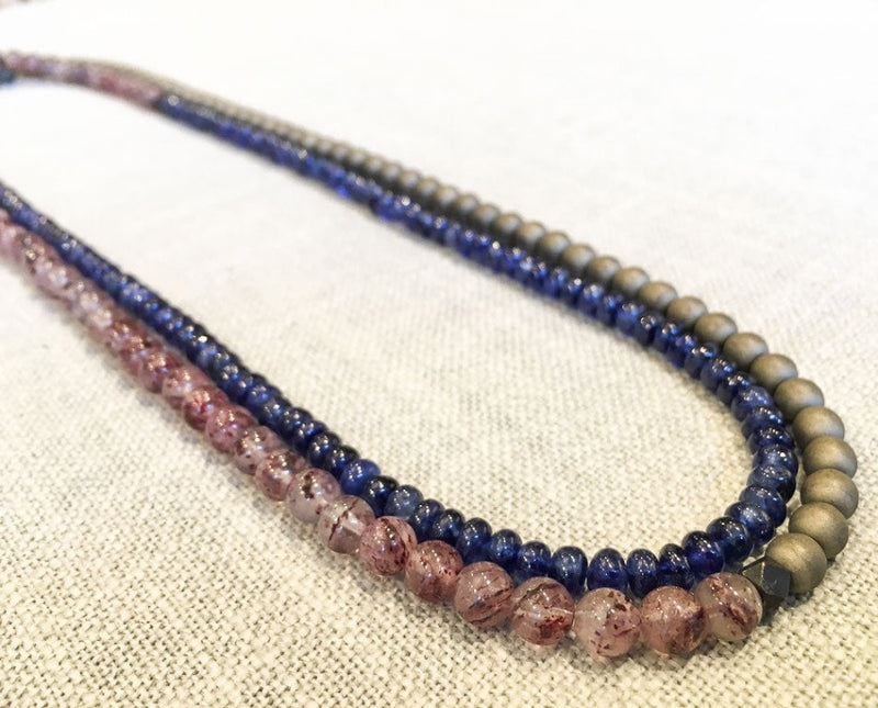 top view of gemstone bead necklace comprising strawberry quartz, blue sapphire and matte bronze hematite