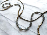 closeup of gemstone bead necklace comprising labradorite, dark grey pyrite and bronze