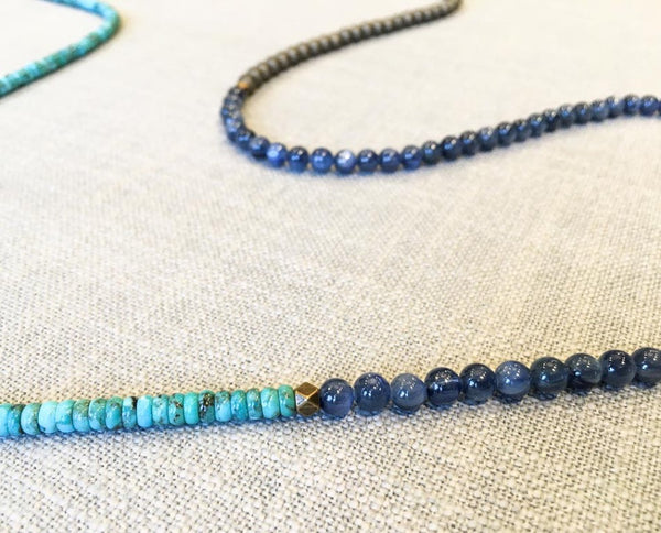 closeup of gemstone bead necklace comprising blue kyanite, turquoise and bronze hematite