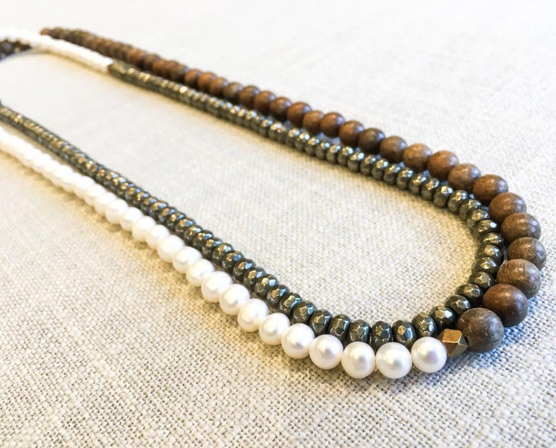 top view of gemstone bead necklace comprising white pearl, pyrite and exotic wood