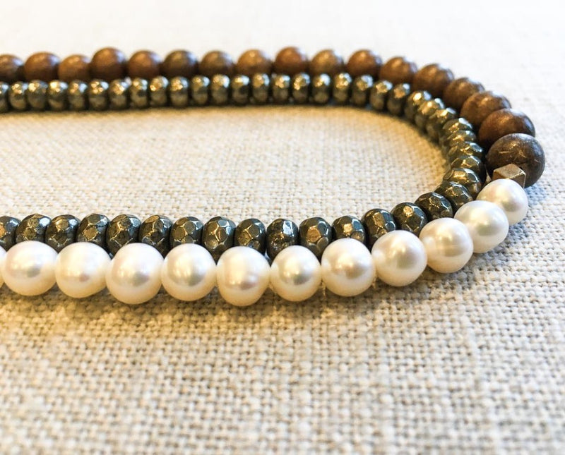 side view of gemstone bead necklace comprising white pearl, metallics and exotic wood