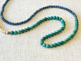 closeup of gemstone bead necklace comprising bone, turquoise and blue kyanite