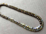 top view of gemstone bead necklace comprising neutral dendritic opal, green labradorite and exotic wood