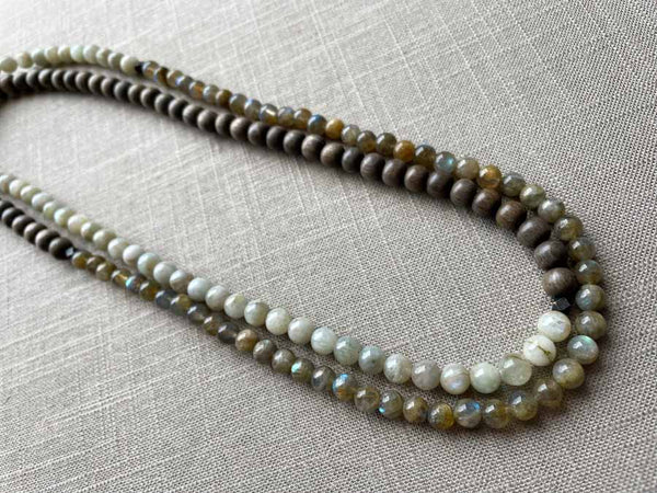 top view of gemstone bead necklace comprising off-white siberian moonstone, green labradorite and exotic wood