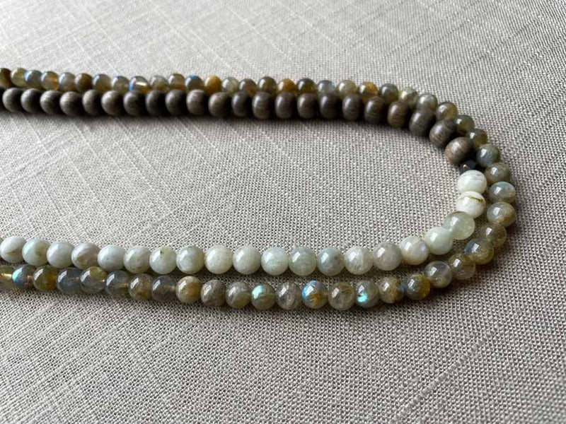 side view of gemstone bead necklace comprising off-white siberian moonstone, green labradorite and exotic wood