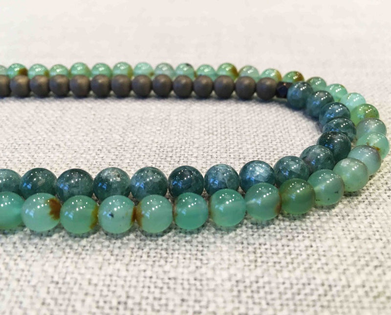 side view of gemstone bead necklace comprising blue kyanite, tea foam chrysoprase and matte bronze hematite