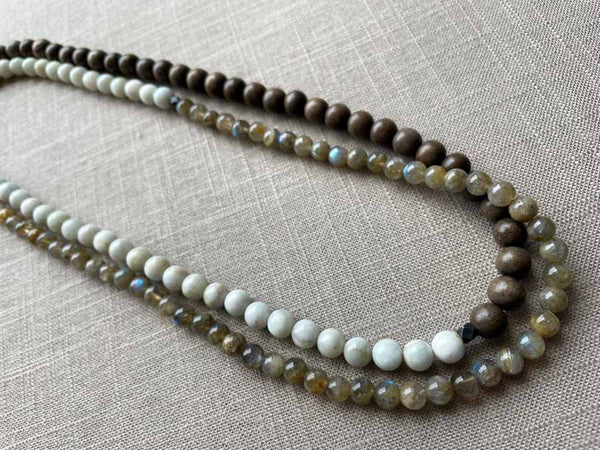 top view of gemstone bead necklace comprising white siberian moonstone, green labradorite and exotic wood