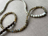 closeup of gemstone bead necklace comprising white siberian moonstone, green labradorite and exotic wood