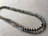 top view of gemstone bead necklace comprising tan prayer beads, black and white tourmalated quartz and dark grey pyrite