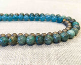 side view of gemstone bead necklace comprising green iolite, bronze hematite and apatite