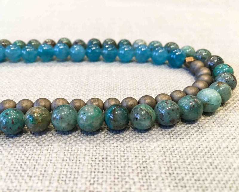 side view of gemstone bead necklace comprising green iolite, bronze hematite and apatite