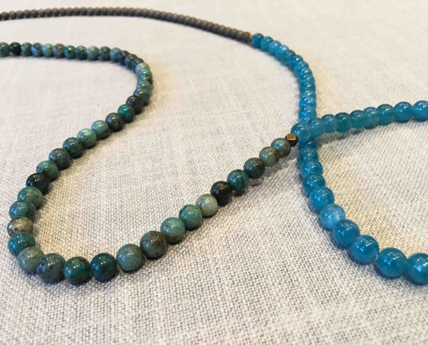 closeup of gemstone bead necklace comprising green iolite, matte bronze hematite and apatite