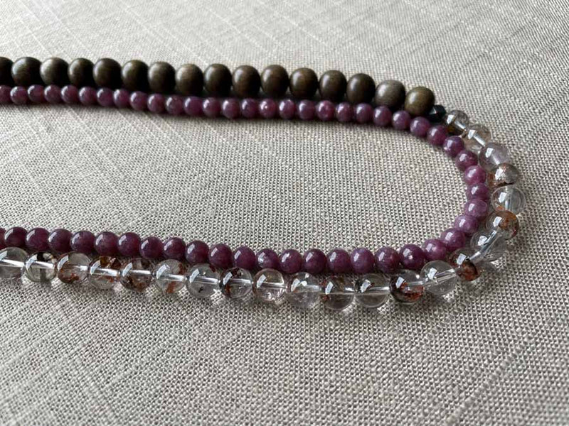 side view of gemstone bead necklace comprising neutral shadow quartz, purple lepidolite and exotic wood