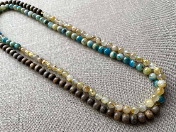 top view of gemstone bead necklace comprising neutral rutilated quartz, blue azurite and exotic wood