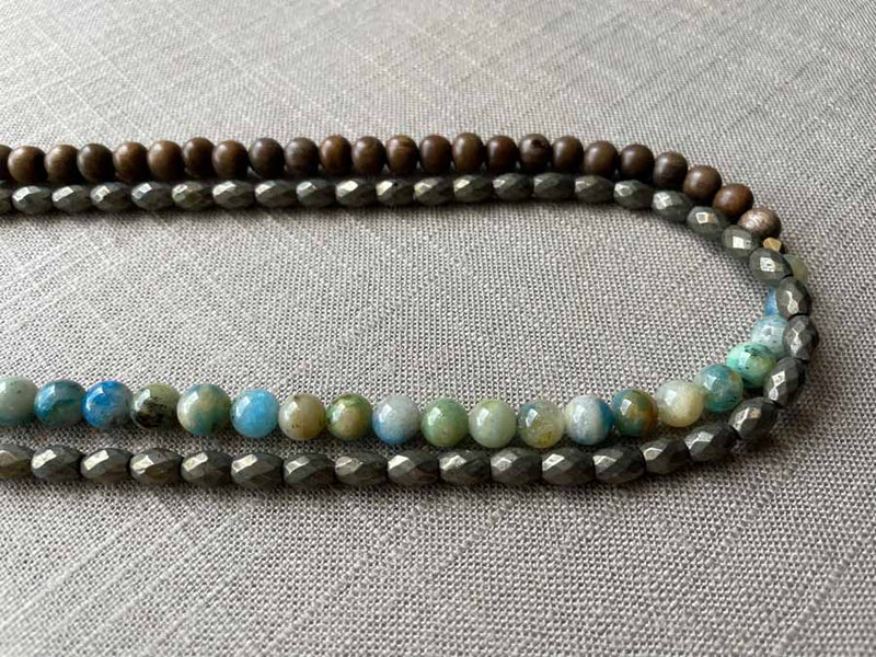 side view of gemstone bead necklace comprising blue azurite, dark grey pyrite and exotic wood