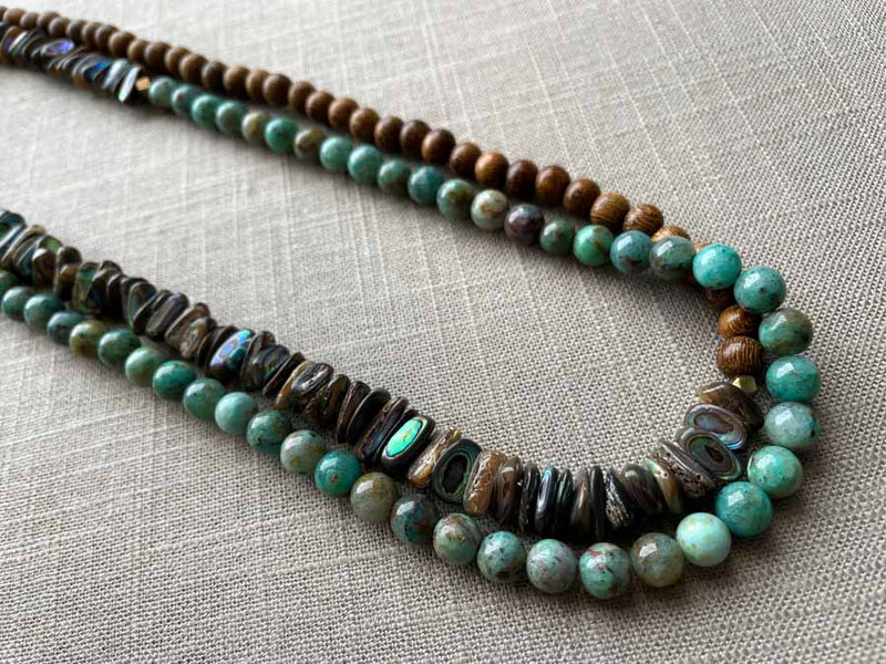 top view of gemstone bead necklace comprising blue chrysoprase, black Tahitian shell and exotic wood