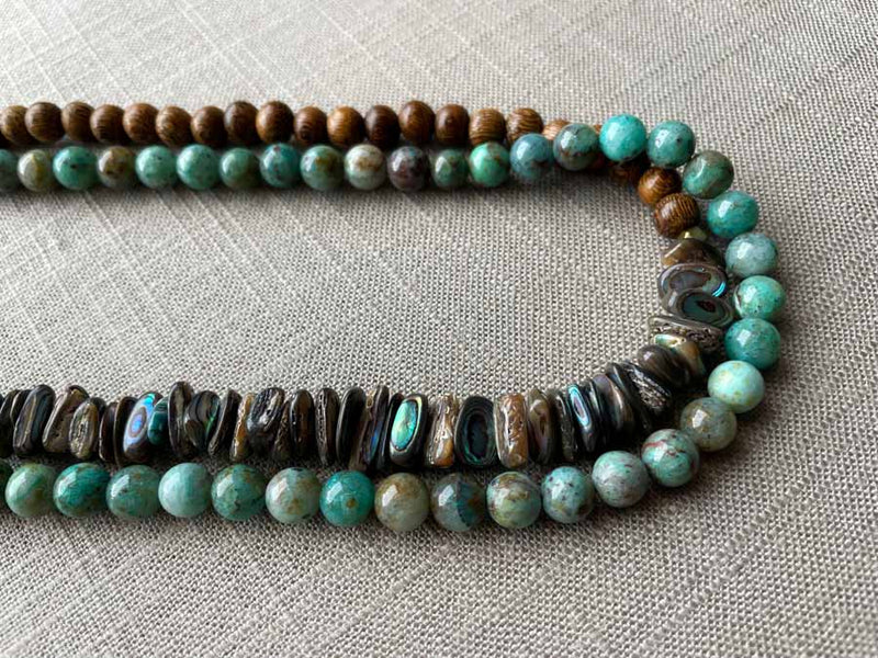 side view of gemstone bead necklace comprising blue chrysoprase, black Tahitian shell and exotic wood