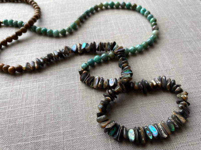 closeup of gemstone bead necklace comprising blue chrysoprase, black Tahitian shell and exotic wood