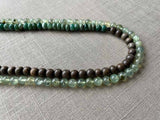 side view of gemstone bead necklace comprising green prehnite, teal aventurine and exotic wood